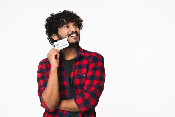 沉思的年轻印度男子考虑用信用卡购物孤立图片下载
