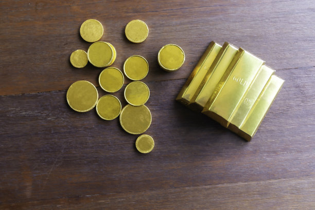 桌子上有金条和一堆硬币。图片下载