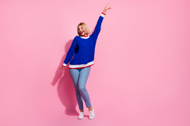 年轻粗心女士的全身照片千禧一代感觉凉爽点手指动态动作舞厅孤立的粉红色背景图片下载