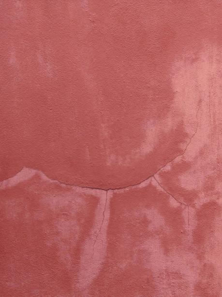 一张有裂缝的红色墙壁的照片。图片下载