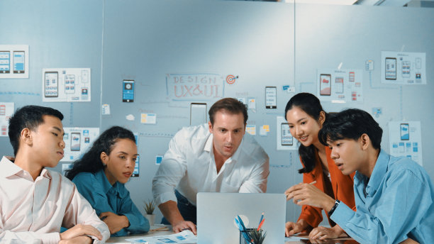 一群聪明的商业团队在笔记本电脑上一起工作的照片。操纵器。图片下载