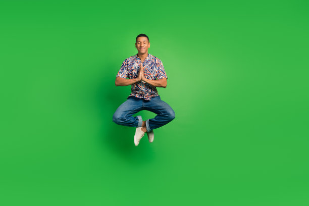 全神贯注的男子练习瑜伽冥想莲花姿势孤立在绿色背景的全长照片图片下载