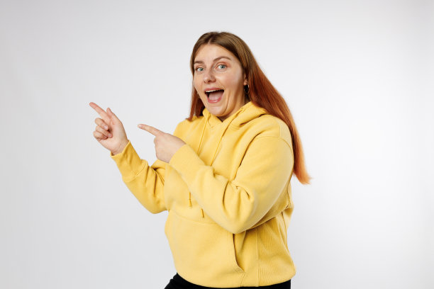 穿着休闲衣服的漂亮开朗的女人用手指打手势，在灰色的背景下孤立地展示自己，工作室的肖像。人类的情感、表情和符号概念。图片下载