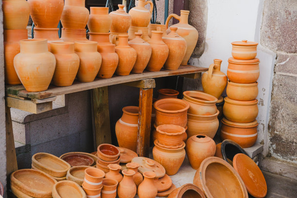 成堆的各种陶罐出售，手工制作的棕色陶罐图片下载
