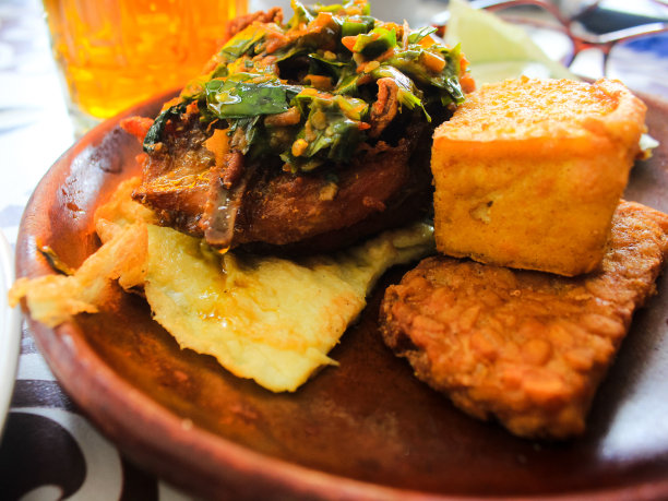 印尼的食物。鸡笼与辣酱豆腐，豆豉，黄瓜，鸡蛋等新鲜蔬菜木盘图片下载