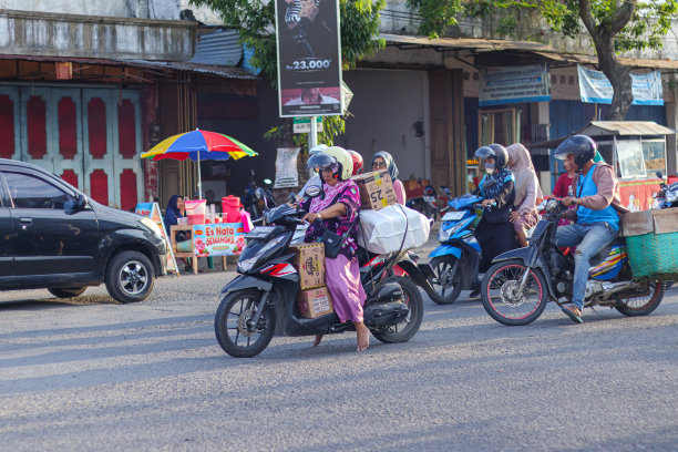 一位中年母亲用一辆自动摩托车载着她买的所有东西图片下载