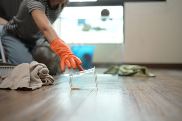 特写:戴着橡胶手套的女人正在打扫凌乱的房子图片下载