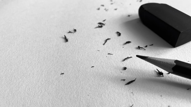 桌子上纸、铅笔和橡皮的黑白照片图片下载