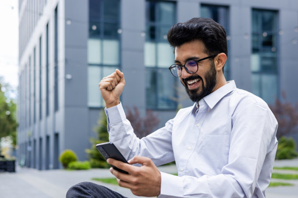 成功的商人在办公楼外庆祝胜利图片下载