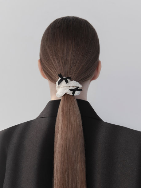 独特的发饰韩国风格时髦的发卷设计师单品美丽的年轻女子棕色长发戴着K-style发饰面料覆盖弹性发带和经典运动夹克时尚模特工作室肖像白底后视图图片下载