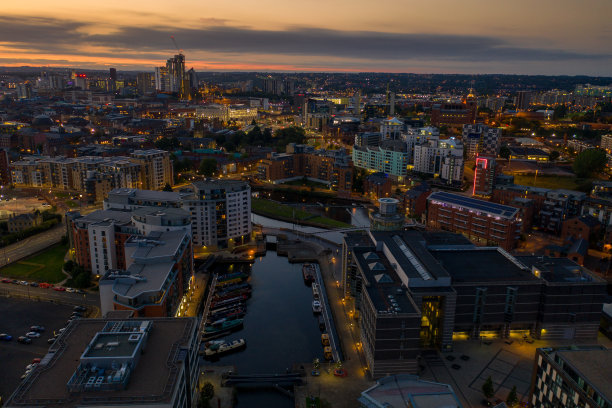 在日落时分，在利兹被称为利兹码头的地区拍摄的夜间航拍照片显示了整个西约克郡的城市，太阳在背景中落下图片下载