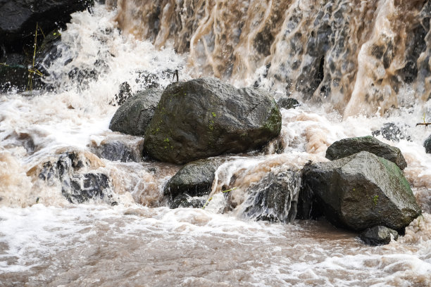 洪水期间阴暗的瀑布溪流和岩石河流的特写照片。国际森林日，世界环境日的概念。图片下载