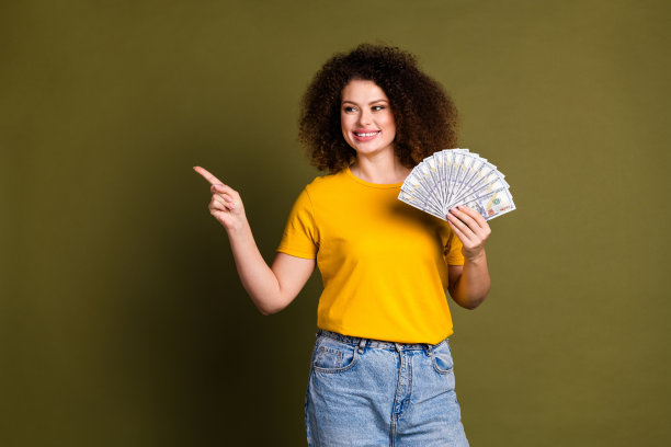 照片年轻的百万富翁富有的女孩指着模拟金融金字塔公司广告孤立的卡其色背景图片下载