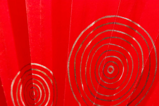 老式的日本手扇纹理与金色和银箔在明亮的朱砂色背景波纹图案。图片下载