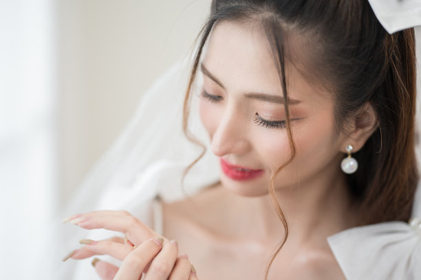 美丽的亚洲新娘与时尚的婚礼发型和化妆。年轻美丽的新娘的肖像在白色的房间里拍摄的婚礼工作室。图片下载