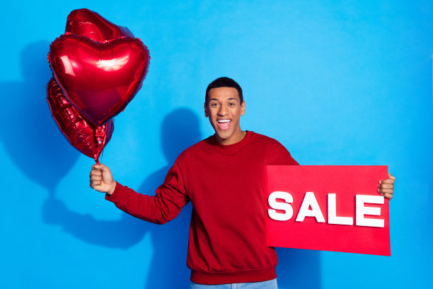 照片积极的好人手拿销售标书心形气球孤立的蓝色背景图片下载