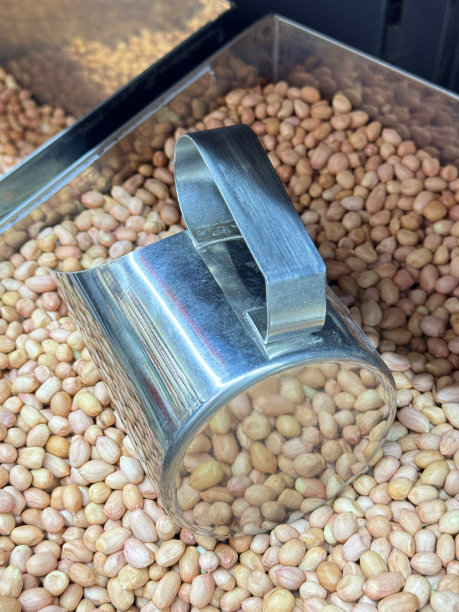 一堆即食食品的特写图片，不锈钢盒子里的去壳花生，用金属舀杯的干粮，按重量出售的市场摊位，健康食品小吃，高架视图图片下载