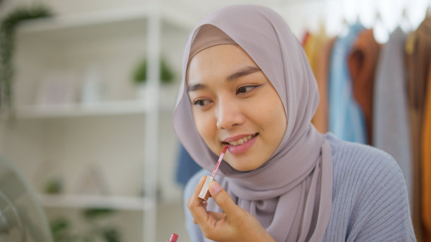 美丽的穆斯林女孩在社交媒体平台上直播故事自拍在家化妆示范。图片下载