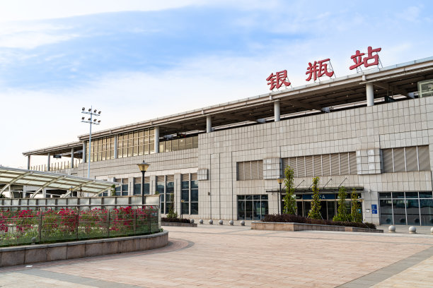 中国广东省东莞市谢岗镇银片站，一个轻轨和城轨车站，蓝天白云下，高速列车在轨道上行驶。图片下载