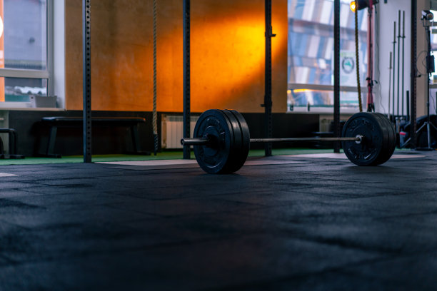 在体育俱乐部的运动板上的杠铃为明亮的橙色背景图片下载
