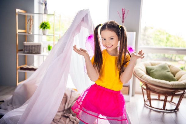 照片肖像迷人的小女孩游戏时间仙女服装有乐趣穿时髦的黄色服装儿童幼儿园游戏室图片下载