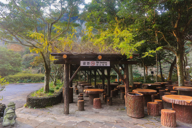 在天池渊瀑布，游客休息的地方有木头形状的水泥座椅图片下载