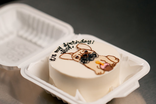 一个白色的盒子里放着一个白色的小蛋糕，上面有一只狗的照片图片下载