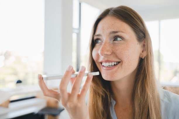 年轻的女经理在家庭办公室用智能手机录制语音信息的特写照片图片下载