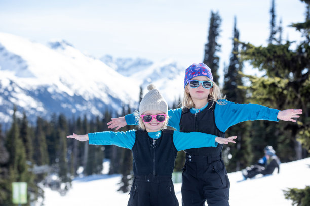 滑雪家庭暂停在滑雪坡上，女孩们玩耍图片下载