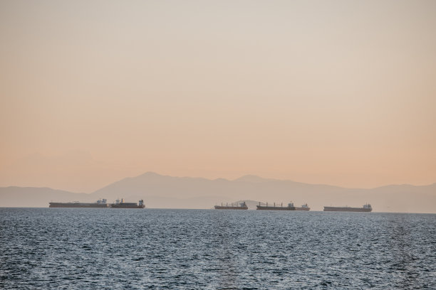 日落时海上的集装箱货船图片下载