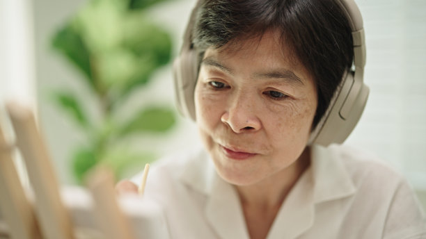 成熟的女人在画布上画画。图片下载