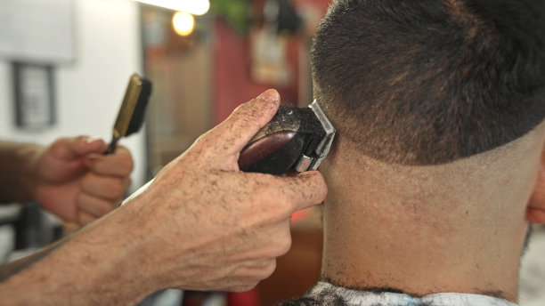 理发店的理发师用电动剃刀剃头。剪男性发型图片下载