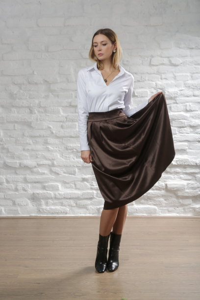 一系列的工作室照片，年轻的女模特穿着白色衬衫和棕色中长裙。舒适优雅时尚。图片下载