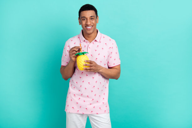 积极的人的照片，带着牙齿的微笑，拿着菠萝杯，冰镇鸡尾酒，空旷的空间孤立在蓝绿色的背景上图片下载