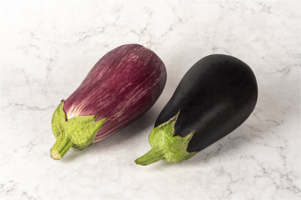 一对不同颜色的茄子在大理石白色背景上的横向照片图片下载