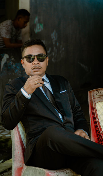 一名男子身穿黑色衣服，戴着墨镜，看着镜头的人像照片图片下载