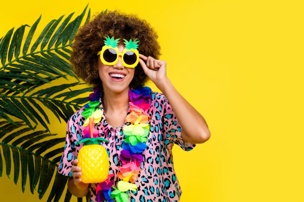 照片中开朗好心情的女子穿着印花衬衫深色眼镜喝着鸡尾酒空旷的空间孤立的黄色背景图片下载