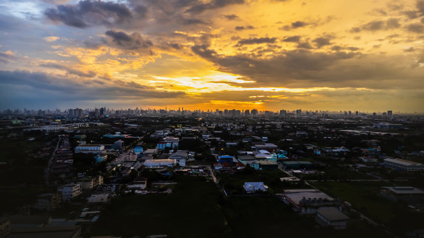 黄昏时的城市鸟瞰图明亮的天空当太阳落山时，城市是橙色和紫色的，城市里到处都是建筑物。有各种形状和大小的摩天大楼图片下载