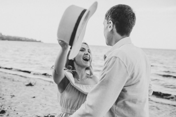 男人和女人在沙滩上奔跑。女性和男性在沙滩上奔跑，享受夏日。一对幸福的夫妇在海边互相看着对方。共度时光。特写镜头。黑白照片图片下载