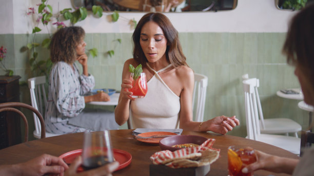 豪华女子在咖啡馆喝鸡尾酒特写。快乐女士谈朋友图片下载