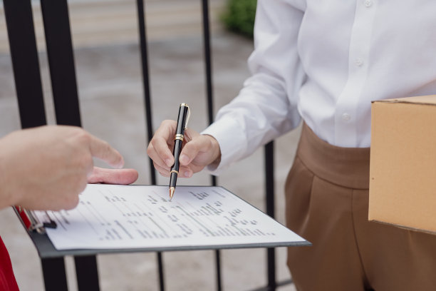 快递员、箱子和物流概念包裹或快递服务站在服务提供商或产品的前门，用于在线购买、运输或电子商务。特写照片图片下载