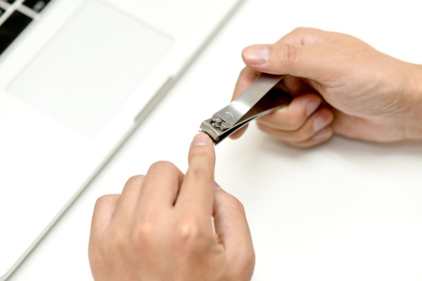 一个男人用指甲钳剪指甲的手图片下载