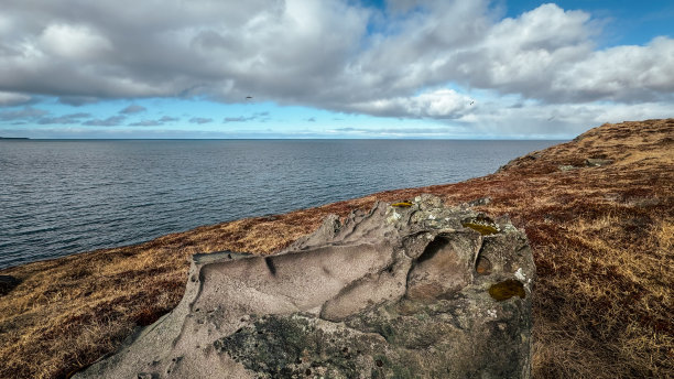 从冰岛多岩石的海岸线俯瞰大西洋。冰岛风景的照片，美丽的云和平静的海洋在春天图片下载