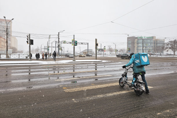 快递员骑着自行车穿过人行横道图片下载