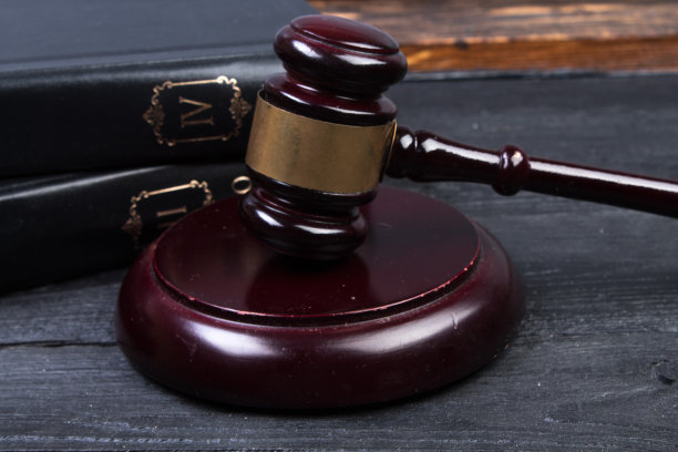 法律概念-在法庭或执法办公室的桌子上打开一本法律书，上面放着一个木制的法官木槌，背景是白色的。文本的复制空间。图片下载