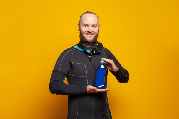 潜水员拿着彩色橙色背景的塑料瓶图片下载