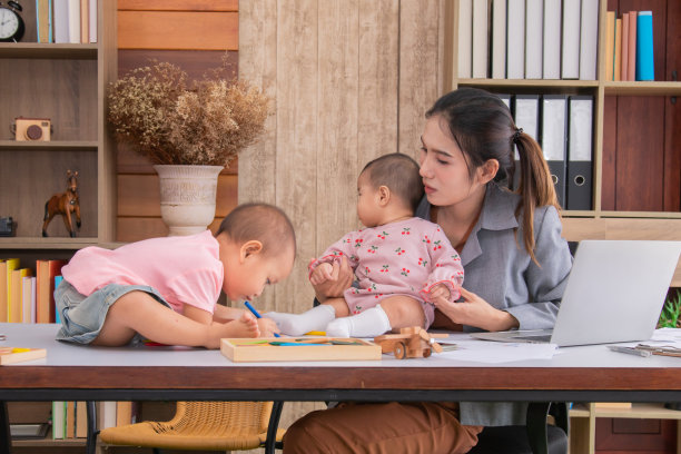 美丽的亚洲母亲困惑多任务，单身母亲不能在孩子玩耍的时候工作，在家工作，照顾混乱的孩子，在隔离社会距离期间Covid-19危机的概念图片下载