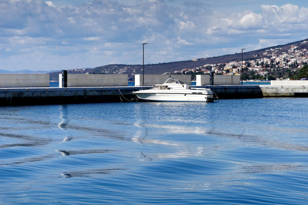 在城市港口用石头防波堤挡风的摩托艇图片下载