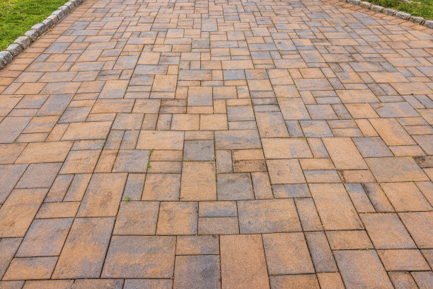 草坪旁红色石头小径的近景。图片下载