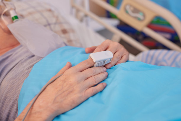 在医院的病床上，老人的手在输液的特写照片图片下载